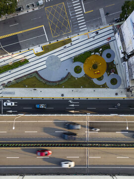 Aerial view of a geometric park with circular patterns and lush greenery contrasting with the linear roads below, Taipei, Taipei City, Taiwan.