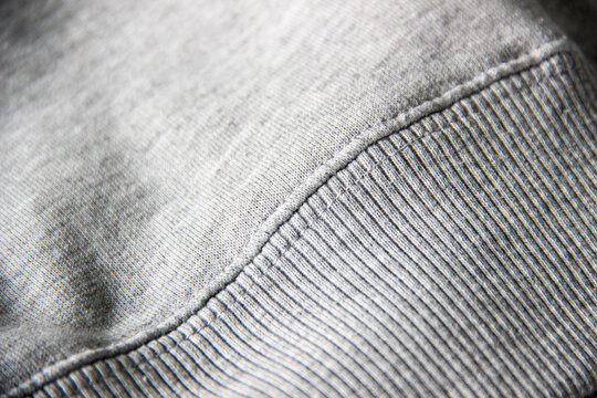 Close up of heather gray sweatshirt hem with rib knit waistband detail and soft fabric texture