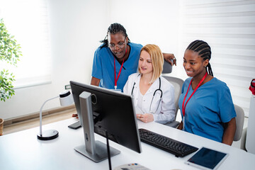 Obraz premium Medical team collaborating on computer in healthcare setting