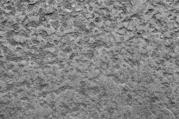 Close view of uneven concrete surface showing rugged texture and natural imperfections. Monochrome pattern emphasizes raw material character and industrial aesthetic. © Semiglass