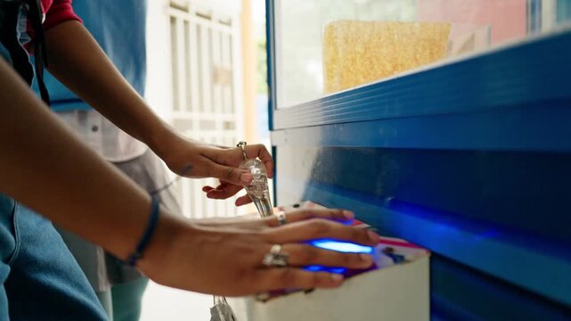Two young women playing claw machine game indoors