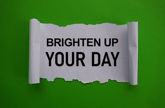 Tear up white paper printed brighten up your day, green background, self-development concept, doing the best thing every day