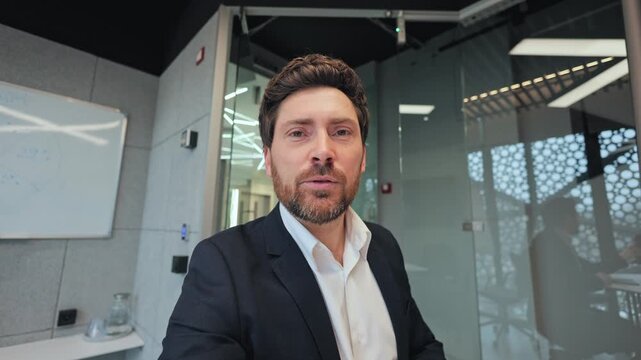 Confident professional engages viewers, conveying ideas and approval through gestures in contemporary office setting. Shows positivity, leadership, successful communication in corporate environment.