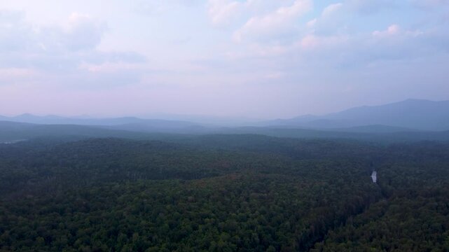 Maidstone, Vermont, an aerial view of the dense northern forest and rolling green mountains of the Northeast Kingdom after sunset.
