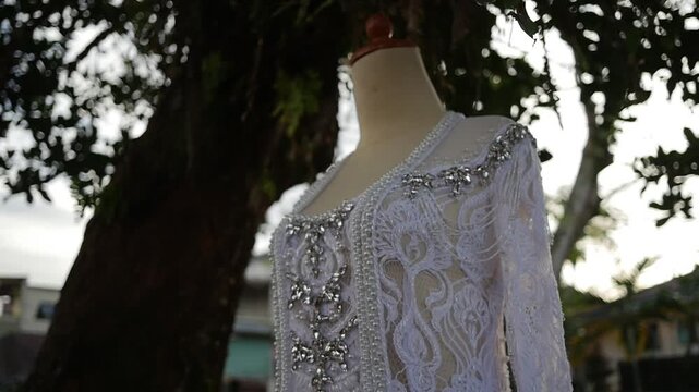 Traditional southeast Asia white wedding dresses complete with decorations and ornaments, worn by the bride and groom. Real time outdoor natural lighting RAW no edit footage video file