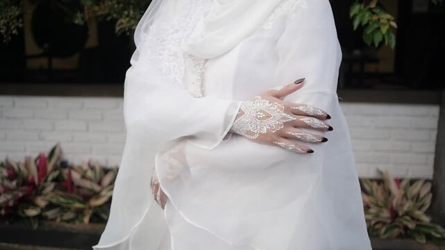 Traditional southeast Asia white wedding dresses complete with decorations and ornaments, worn by the bride and groom. Hand pose Real time outdoor natural lighting RAW no edit footage video file