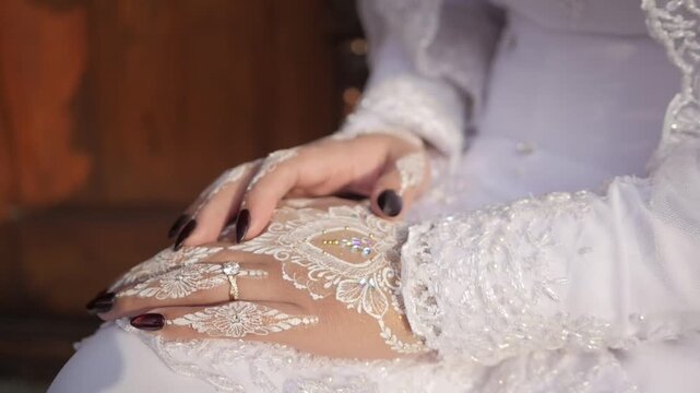 traditional southeast Asia white wedding dresses complete with decorations and ornaments, worn by the bride and groom. hand closeup. real time outdoor natural lighting RAW no edit footage video file.