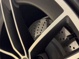 Detailed shot of a stylish car wheel with brake disc, showcasing modern design and automotive details. Perfect for car e