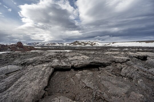 Petrified lava, lava fields and snow-covered volcanic landscape, crater of Askja volcano, Icelandic highlands, Iceland