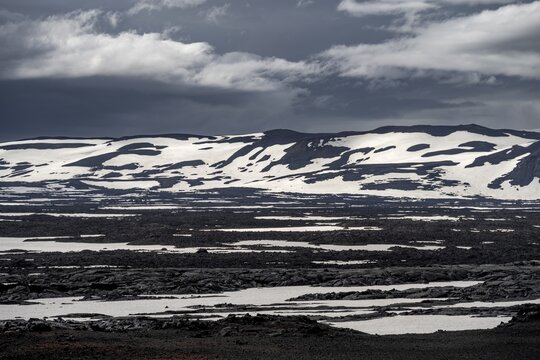 Snow-covered volcanic landscape with volcanic sand and petrified lava, crater of Askja volcano, Icelandic highlands, Iceland