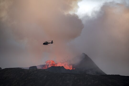 Helicopter flying over smoking active volcanic crater, glowing lava, volcanic eruption, active table volcano Fagradalsfjall, Kr&yacute;suv&iacute;k volcanic system, Reykjanes Peninsula, Iceland
