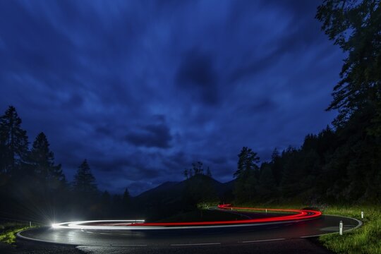 Driving car in serpentine with light strip at blue hour, Reutte, Au&szlig;erfern, Tyrol, Austria