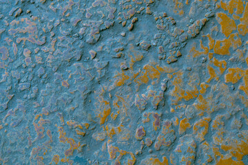 Uneven surface featuring blue and orange weathered coloration and rugged texture. Irregular shapes and worn material create strong abstract and industrial appearance.