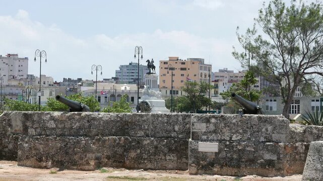 Statue of M&aacute;ximo G&oacute;mez in Parque Martires del 71, with the Museum of the Revolution in the background and canons in the foreground. Located in Havana, Cuba.