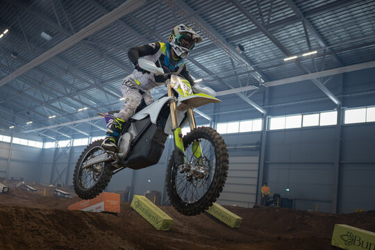 Latvia, Riga August 27, 2025,  regular training Person performing a jump on a dirt bike in an indoor arena