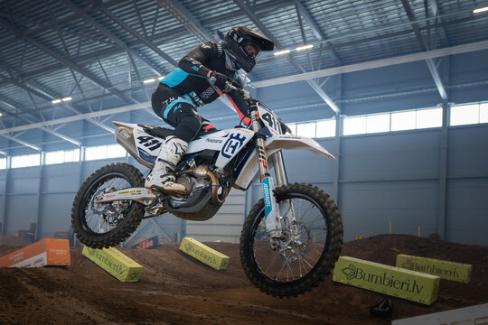 Latvia, Riga August 27, 2025,  regular training Rider performing a wheelie on a dirt bike in an indoor arena
