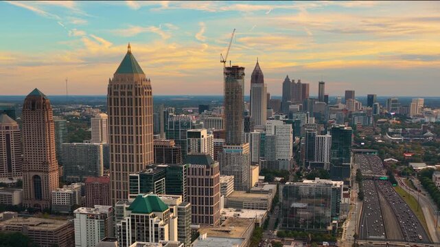 Downtown Atlanta cityscape with urban highways, driving cars and surrounding skyscraper buildings. Speed, progress and city connectivity concept.
