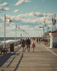 Fototapeta premium Family Walking Along Ocean Pier: Summer Vacation Fun on a Seaside Promenade