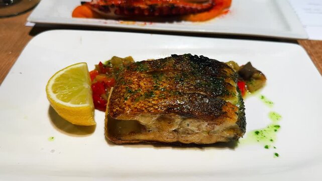A piece of fried white fish served on a plate with steamed vegetables.