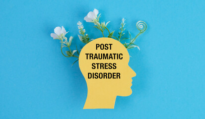 Post Traumatic Stress Disorder text on a human head profile with flowers growing out for PTSD...