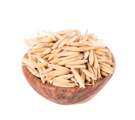 Unpeeled oat grains isolated on white background. Organic dry oat seeds in wooden bowl. Clipping path.