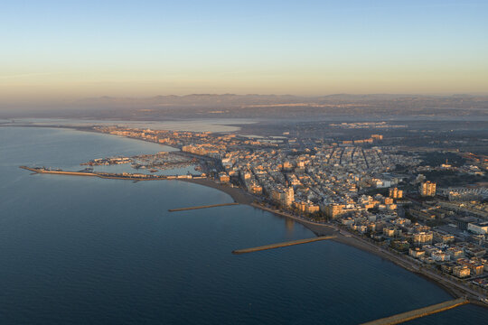 Aerial view of the coastline where the gentle turquoise sea meets the sandy shore, contrasting with the urban spread, Santa Pola, Valencian Community, Spain.