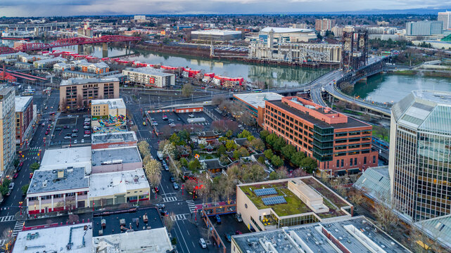Aerial view of the Lan Su Chinese Garden nestled amid city buildings, with bridges stretching over the river, Portland, Oregon, United States.