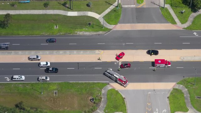 Emergency responders assist victims at vehicle crash site on city street in Florida. Car accident response by first aid and rescue services in USA.