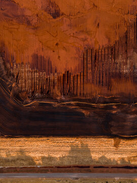 Aerial view of an abstract landscape, with strokes of deep browns and burnt oranges creating a textured, dreamlike scene, Aluminium Refinery, Western Australia, Australia.