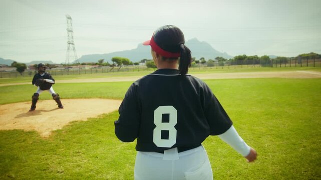 Female baseball pitcher throws to catcher on the field