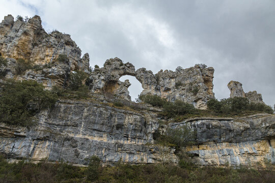 Aerial view of the arch rock formation, a natural wonder etched in stone against the backdrop of a cloudy sky, Orbaneja del Castillo, Castilla y Leon, Spain.