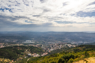 Fototapeta premium Expansive high altitude panorama of Covilha and surrounding valleys under dramatic cloud sky, Portugal, Covilha, 16 October 2025