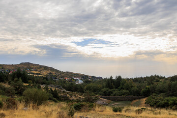 Scenic mountain valley with village and dramatic sun rays over Serra da Estrela near Covilha, Portugal, Covilha, 16 October 2025