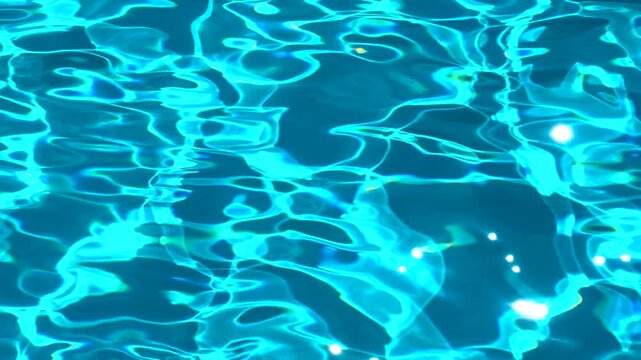 Ripples and sun glare creating a caustic pattern on a swimming pool's clear blue water surface