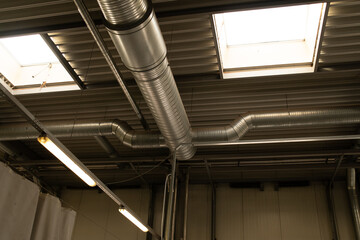 Ventilation pipes under the ceiling, part of an exposed  system inside a building.
