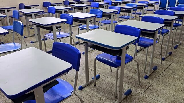 Empty classroom interior with rows of desks and school lockers