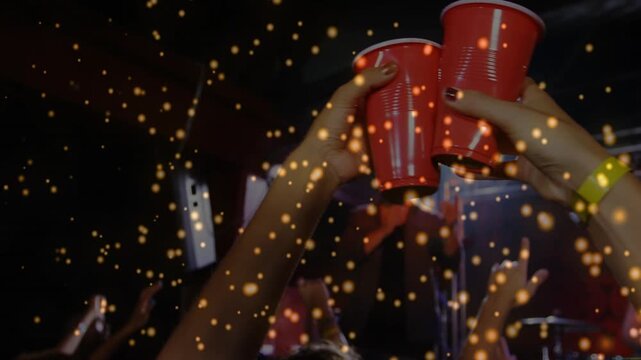 Singer cueing crowd in concert, toasting with red cups, camera moving to cups, gold overlaying cups