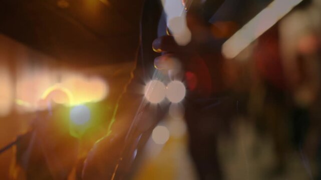 Singer and guitarist performing on platform, train lights causing superimposed silhouettes, busking