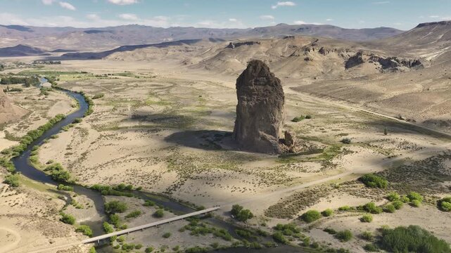 wide aerial view showing the colosal Piedra Parada rock formation standing next to the winding Chubut River in Patagonia, Argentina