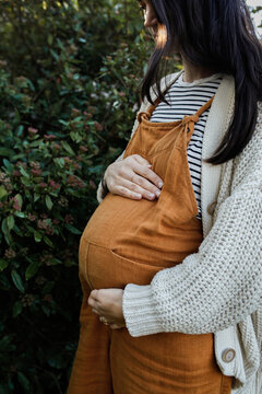 Pregnant Woman outside holding belly