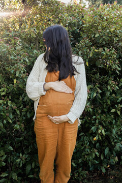 Pregnant Woman outside holding belly
