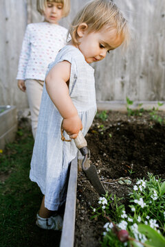 young girls playing in the dirt garden