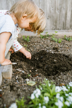 young girls playing in the dirt garden