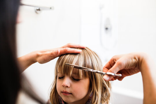 Mom giving daughter a haircut