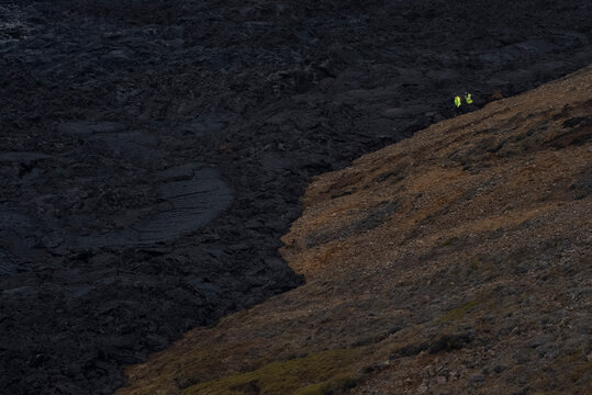 People Standing at the Edge of a Volcanic Landscape