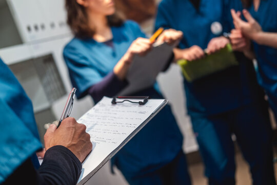 Veterinary staff collaborating on patient records clipboard