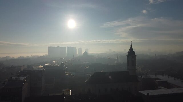 Drone flight above the church in the smog and fog in the morning. Zemun and New Belgrade district, Belgrade, Serbia, Europe