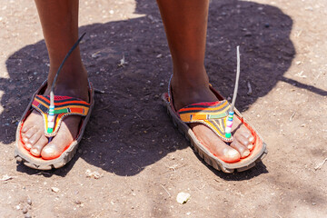 African feet in elaborately decorated sandals with car tyre soles.