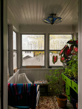 Cozy Sunroom With Plants and love Messages Written on Glass