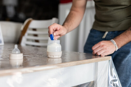 a man preparing a baby bottle